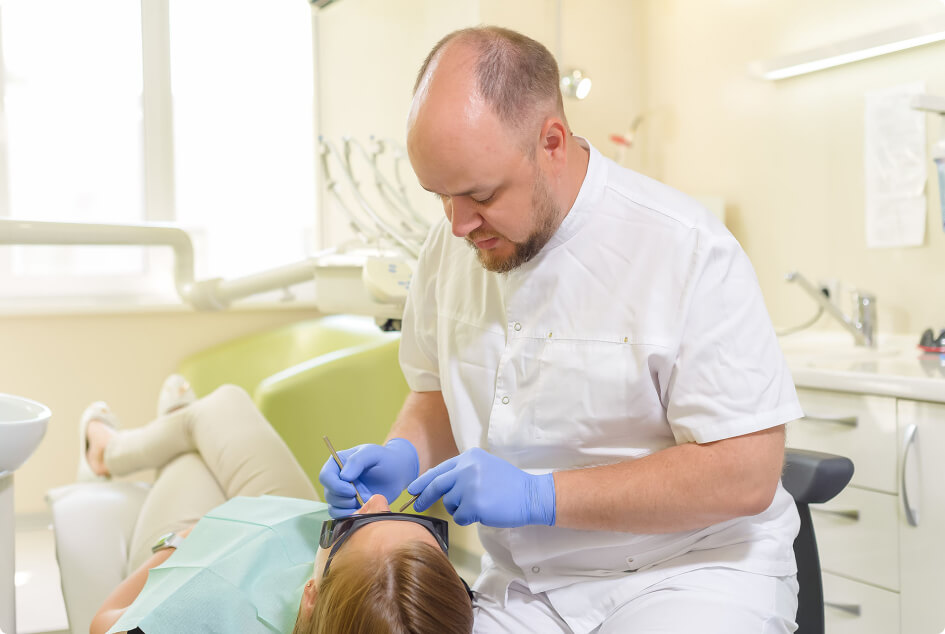Врач «Денити» Илья Рогожников проводит процедуру по реставрации зубов
